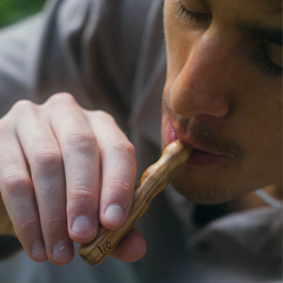 Uomo che fa un tiro da un diffusore Lio in legno d'ulivo